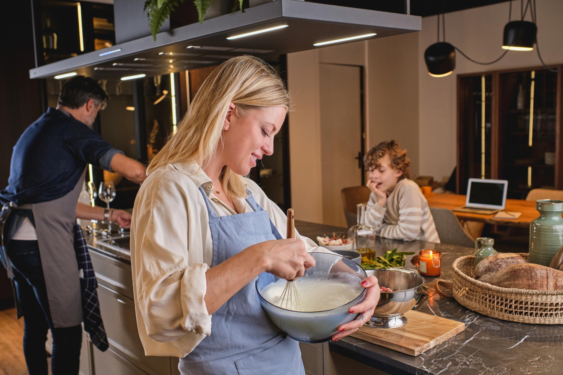 Family cooking together in a kitchen with countertops