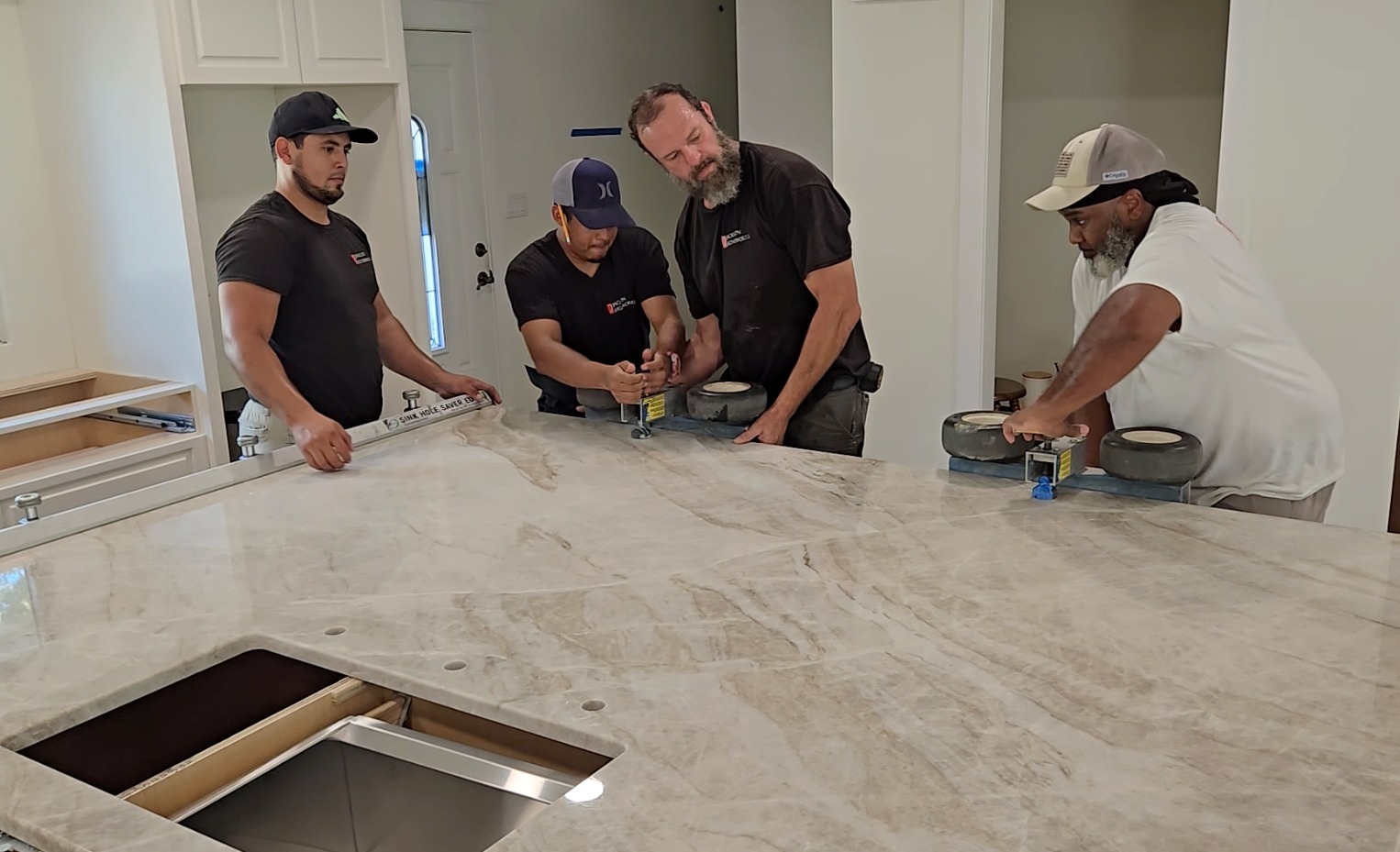 countertop installation process technician setting a stone slab on kitchen cabinets
