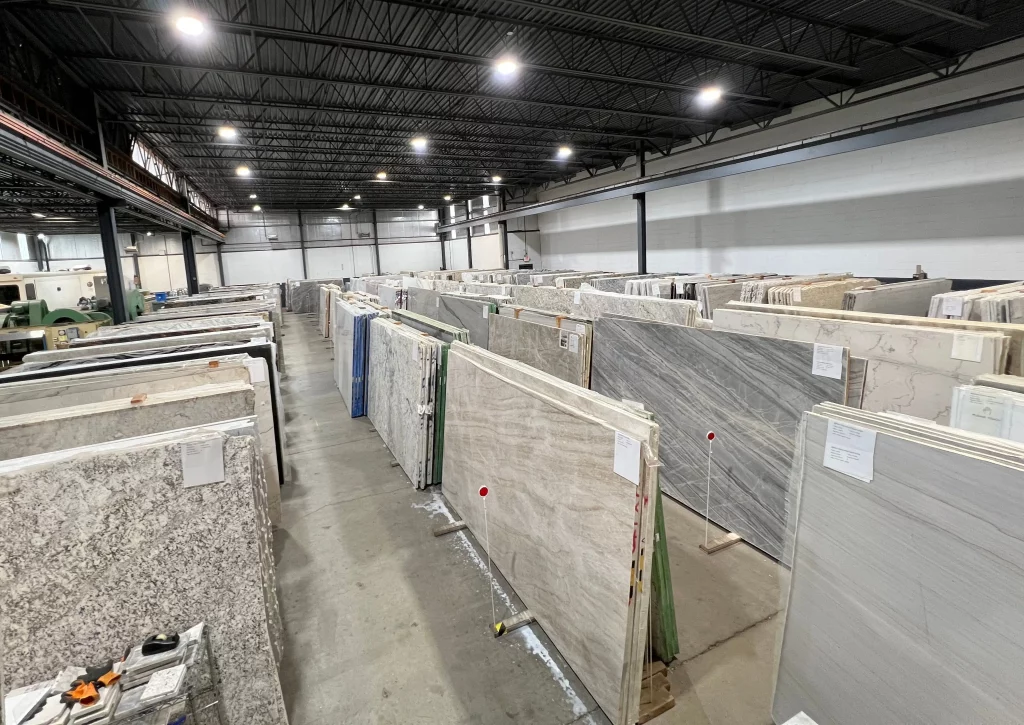Rows of granite and marble slabs displayed in spacious Jackson Stoneworks warehouse